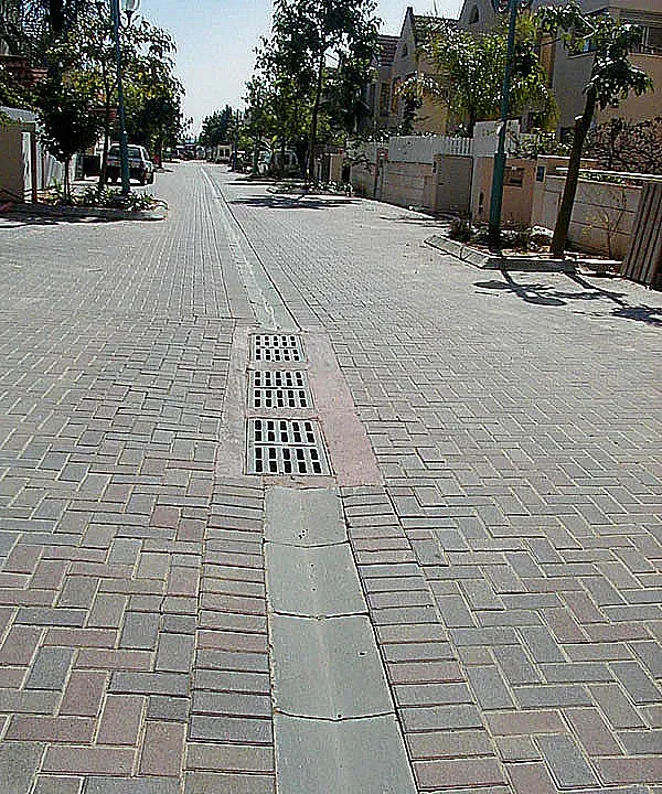 מדרכה מרוצפת באבנים משתלבות עם תעלת ניקוז במרכזה